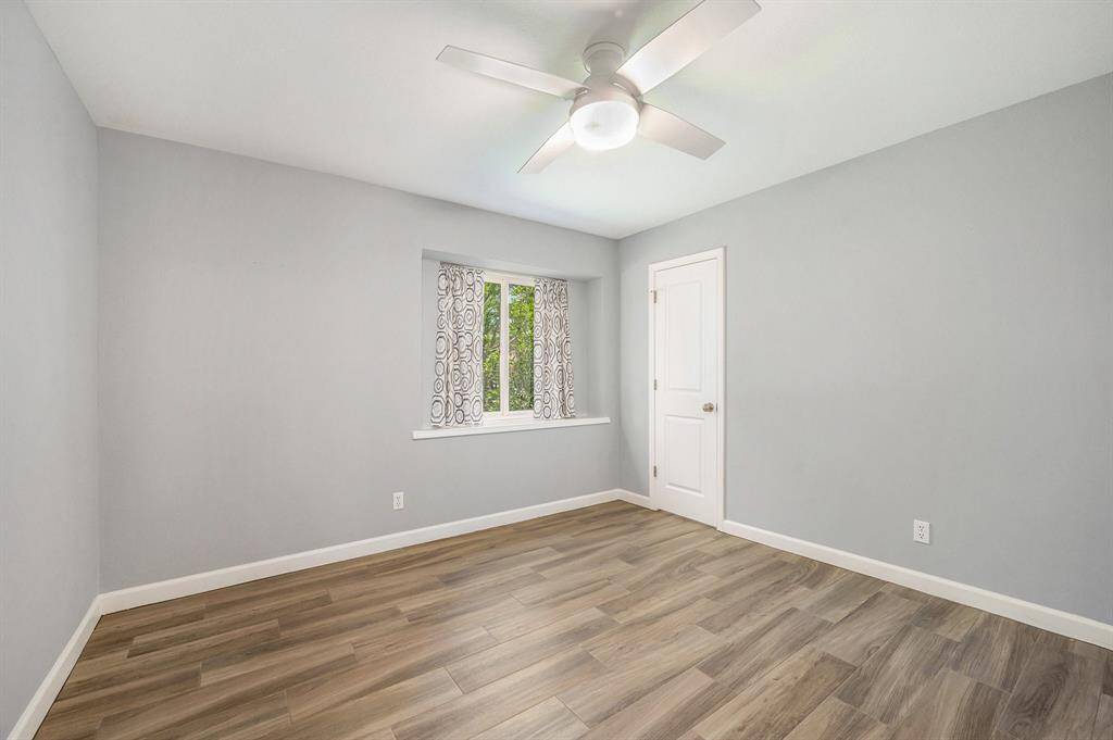 One of two secondary bedrooms with updated ceiling fans, window coverings, enhanced base boards and descent closet space.