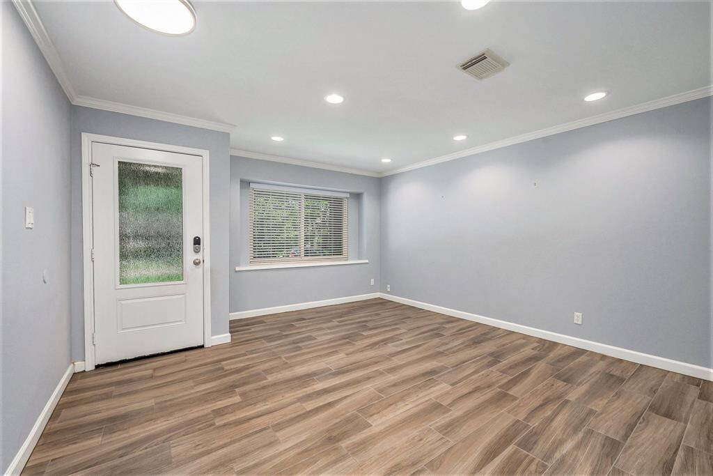 Enter onto the wood look tile floor into the formal dining room featuring recessed lighting, crown molding and neutral paint. This front room can be used as a flex room for whatever your needs may be.