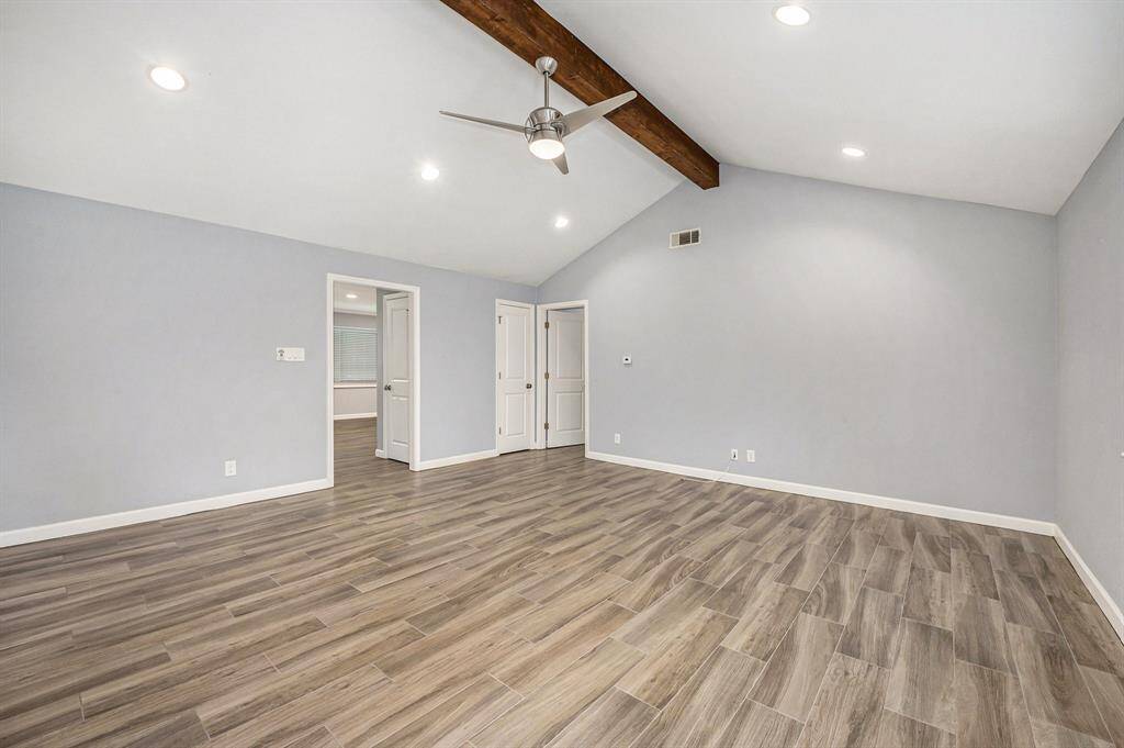 Front hall flows seamlessly into the roomy family room with high ceiling, dark beam, updated ceiling fan and recessed lighting.