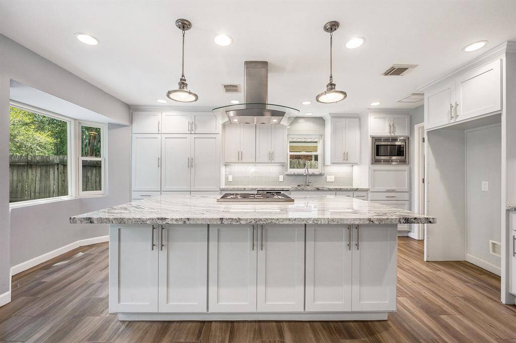 Extensive granite island offering nice breakfast bar, recessed and pendant lighting with 5 burner gas stove and stainless vent hood. Chef kitchen offers so much storage and counter space for all your cooking needs.
