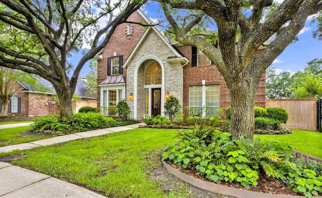 Gorgeous mature oak trees, easily maintained garden beds, and stunning brickwork bring lots of curb appeal to the property.