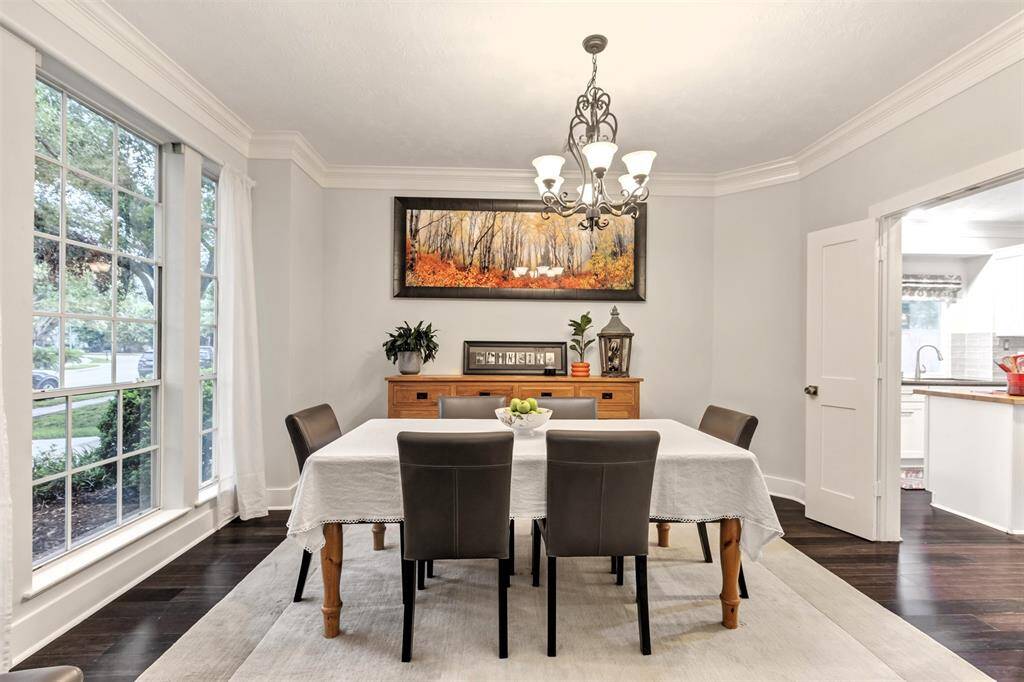 The formal dining room is full of charm with floor-to-ceiling windows that let the light pour in, crown molding for a touch of elegance, and French doors that lead straight into the kitchen—because seconds shouldn’t be far away.