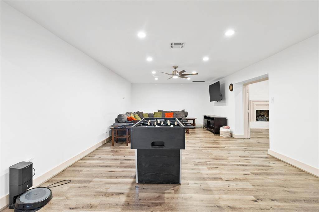 Your formal living room offers a spacious and flexible layout, ideal for use as a media room, game room, or family lounge. Recessed lighting and neutral walls create a bright, inviting atmosphere, while wide plank flooring adds warmth and character. A ceiling fan ensures comfort, and the open doorway leads directly to your spacious flex space, enhancing the flow for both entertaining and daily living.