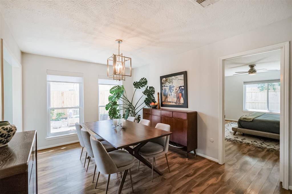 The light and bright formal dining room showcases laminate floors and an updated light fixture.