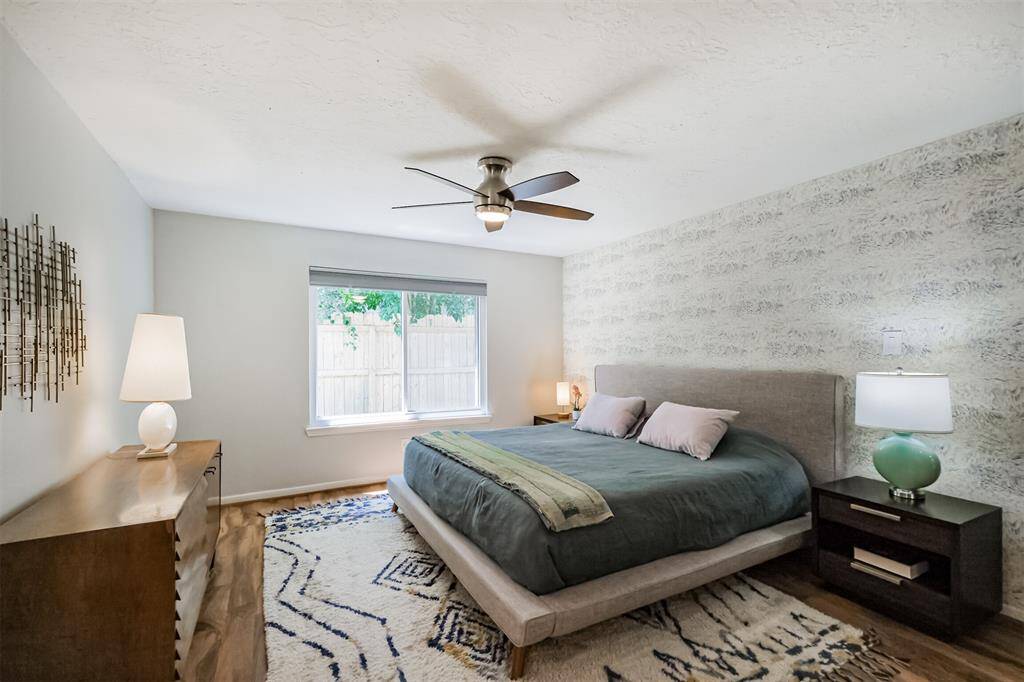 The spacious primary bedroom features laminate floors and an updated ceiling fan.