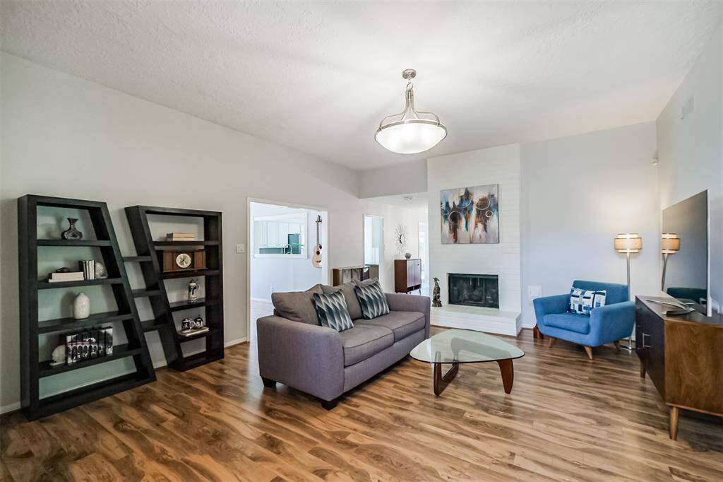 The den features high end laminate floors, wood burning fireplace and updated light fixture.