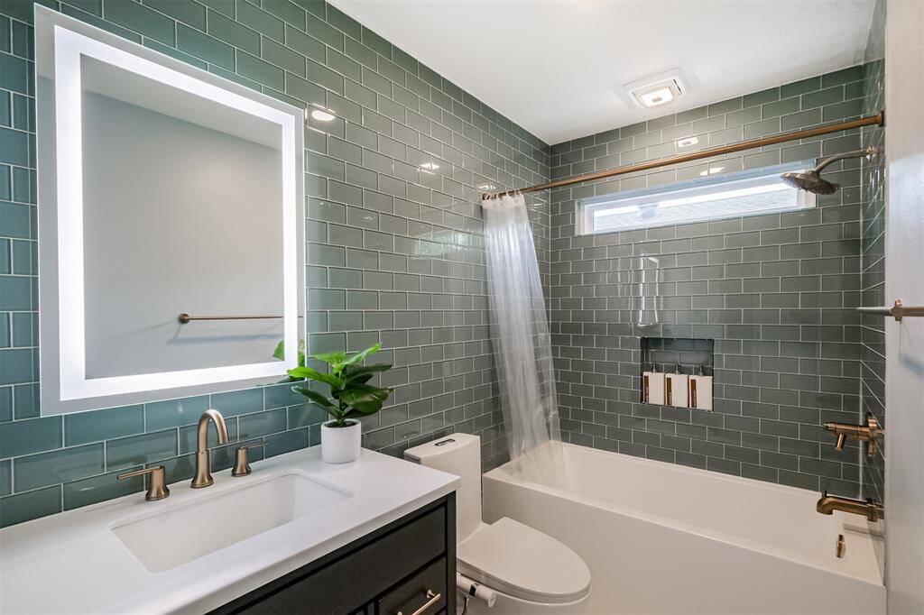 The second full bathroom has been renovated with a updated vanity, bidet, tub+shower duo with tile surround and brushed gold fixtures.
