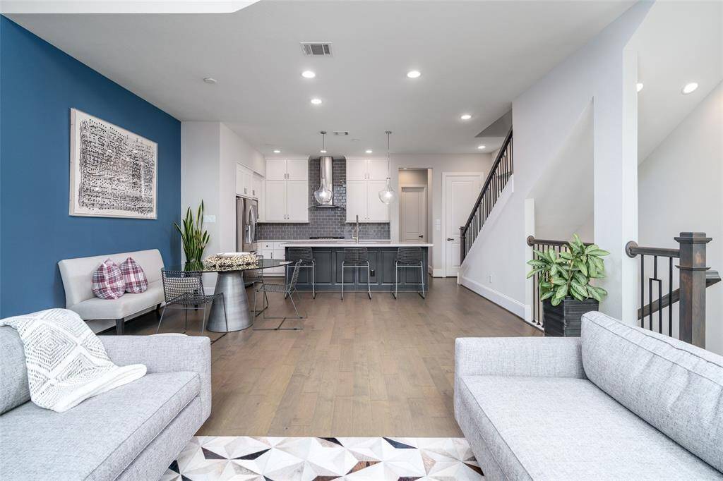 Explore the seamless elegance of this open-concept living space, perfect for entertaining and relaxation, highlighted by a striking accent wall and abundant natural light.