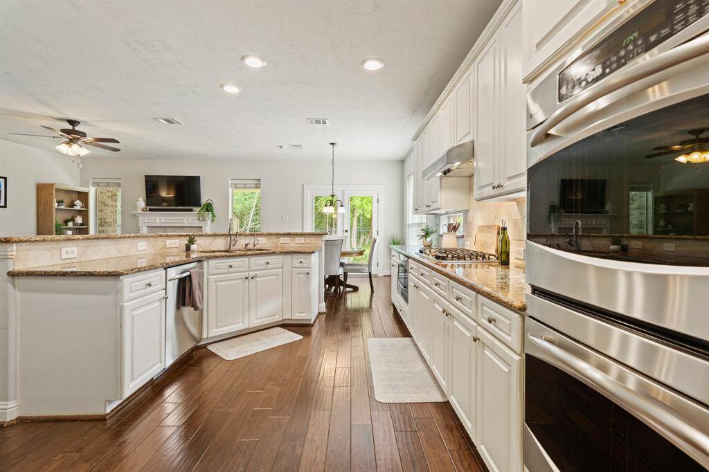 The chef’s kitchen features stainless appliances, double ovens, abundant counter space, a pantry, and breakfast bar.