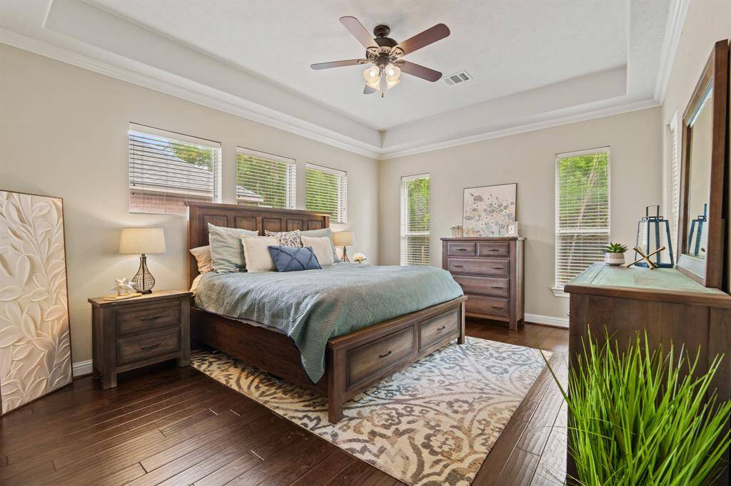 The spacious first-floor primary suite is truly luxurious—bathed in light and wrapped in rich hardwood floors.