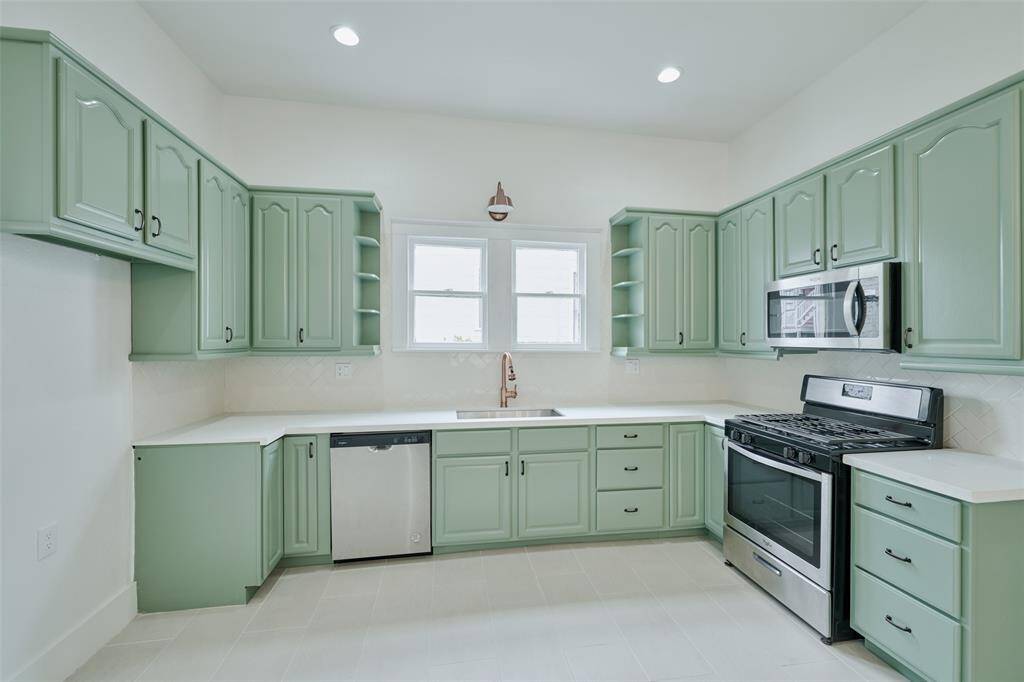 View of Breakfast Room and Pantry located in the kitchen, showing the adjoining back room with large windows, providing additional natural light.