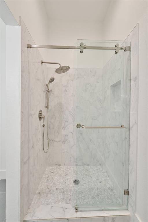 Discover the Hollywood-style primary bathroom thoughtfully renovated to include the historic clawfoot tub, elegant tiled wall, and modern double floating sink.