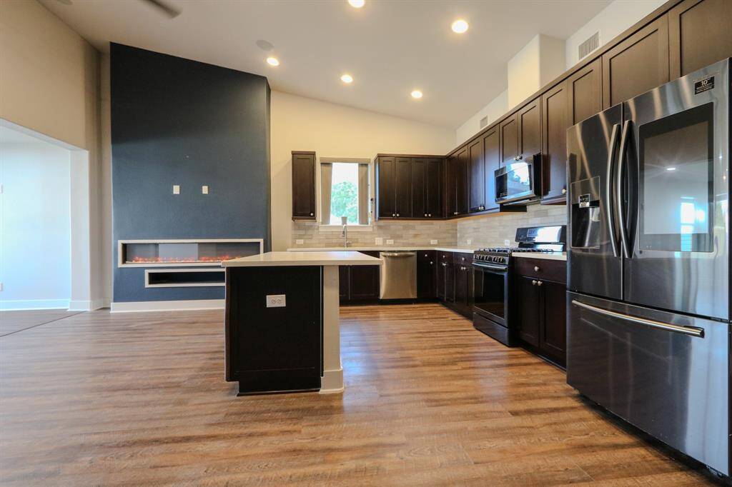 Kitchen with stainless appliances, qurtz counter top, an island & gas range.