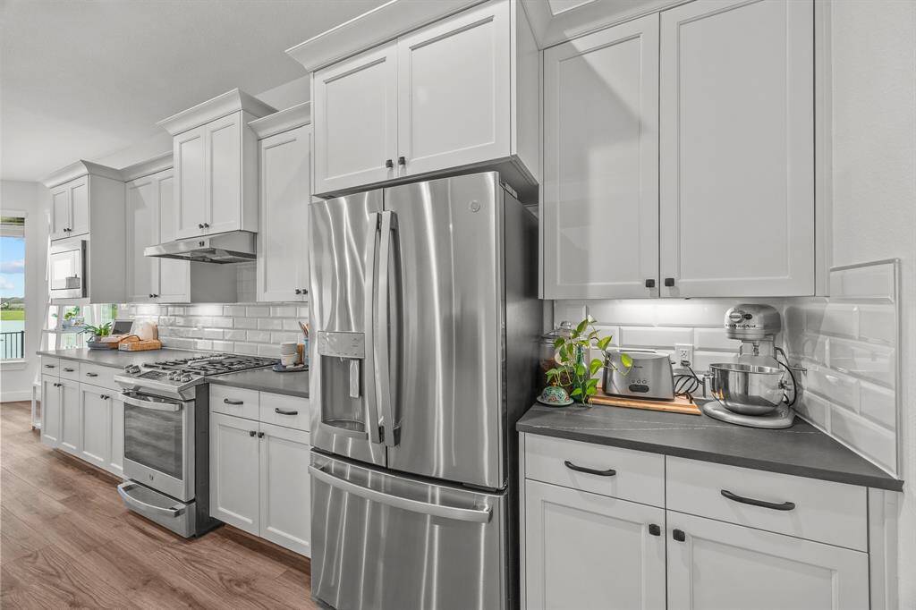 Discover elegance in this kitchen, featuring ample storage and an open, airy design that enhances the home's charm.