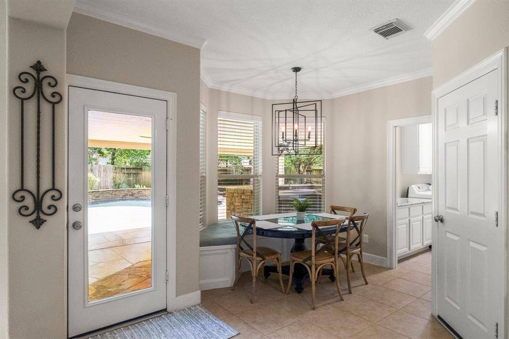 Look at the bright breakfast nook with large windows, a modern light fixture and a convenient built-in bench that has storage underneath!