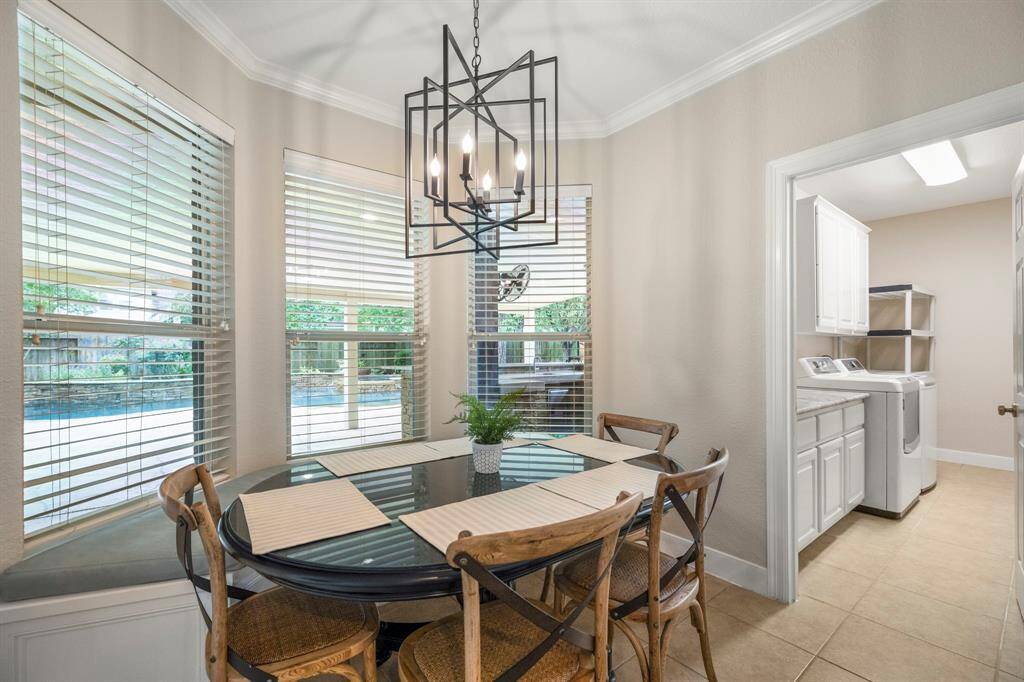 The windows at the breakfast table bring the outdoors in and offer a tranquil view of the backyard oasis.
