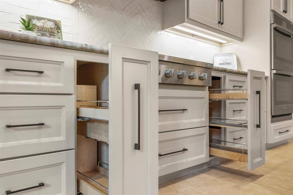 Chef's delight kitchen with a 6-burner gas cooktop and convenient pull-out storage is perfect for culinary enthusiasts. The herringbone backsplash adds a classic touch.