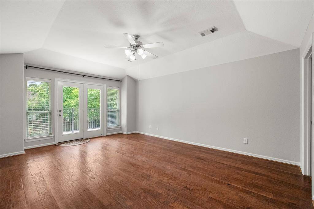 Upstairs gameroom with neutral walls and a walk out balcony overlooking the pool and backyard.