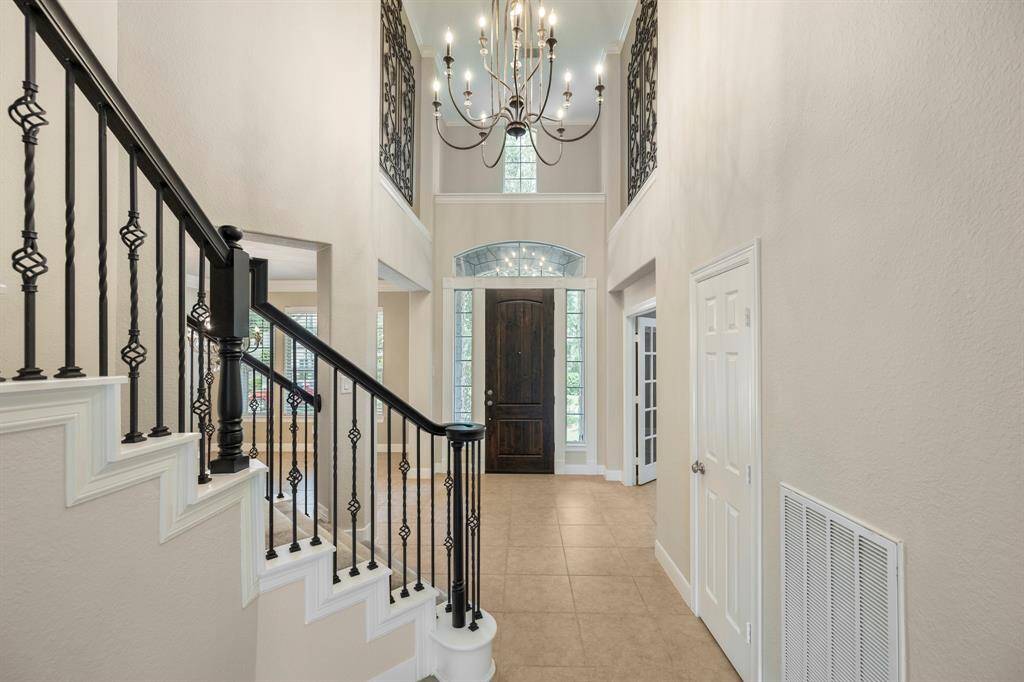 Entry is well-lit with natural light and a pretty chandelier creating a welcoming ambiance.