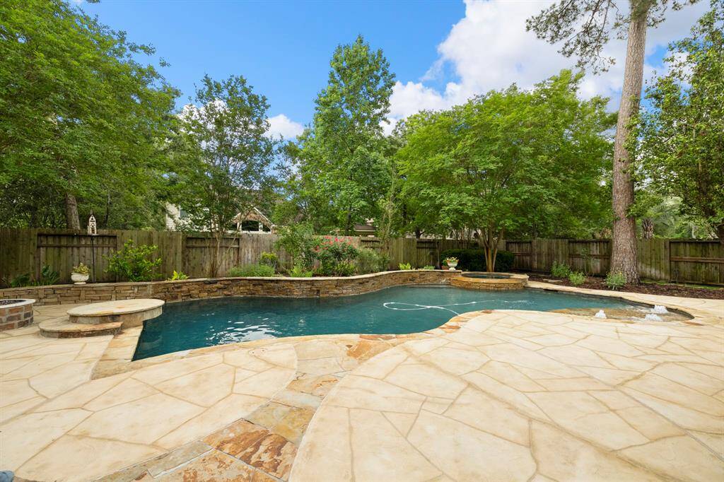 Backyard oasis featuring large pool/spa with recently added custom decking. Lush landscaping provides for a relaxing day at the pool.