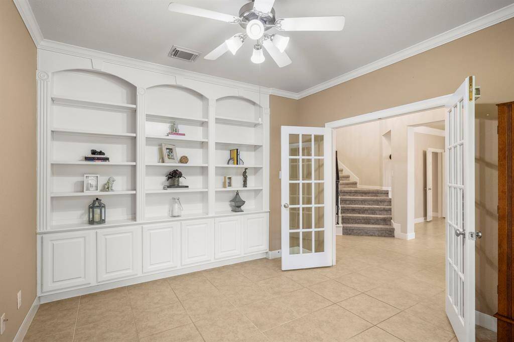 Home office with divided light french doors adds a touch of elegance and practicality. Built in cabinets and bookshelves for added storage.