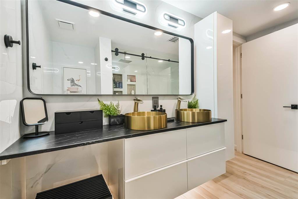 The sumptuous primary bath features multiple lighting sources and double sinks.