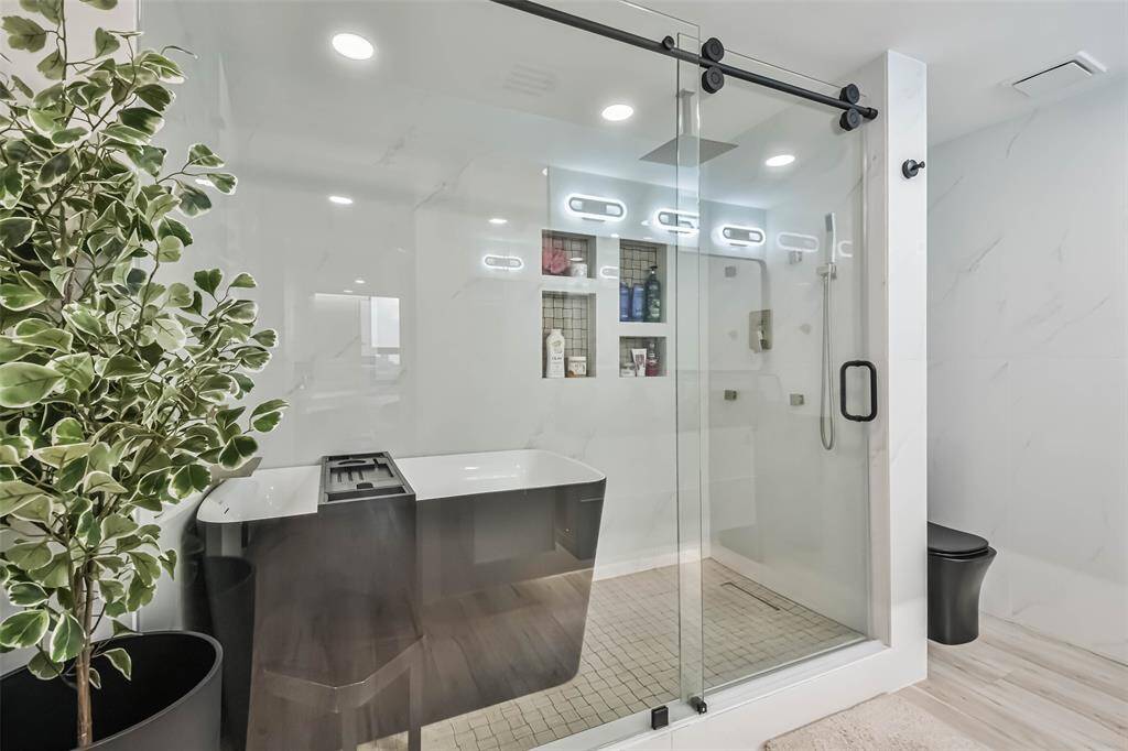 The primary ensuite has a unique wet room which includes body sprays, a hand-held spray, and fabulous soaker tub.