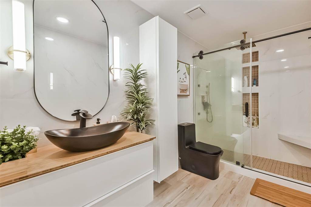 The elegant guest bath features a walk-in shower with basket weave tile accents.