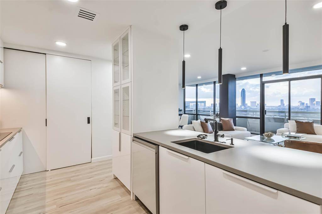 The state-of-the-art kitchen is open to the living/dining area. The gorgeous glass front cabinet is perfect for display.  Quartz countertops anchor the sophisticated design.