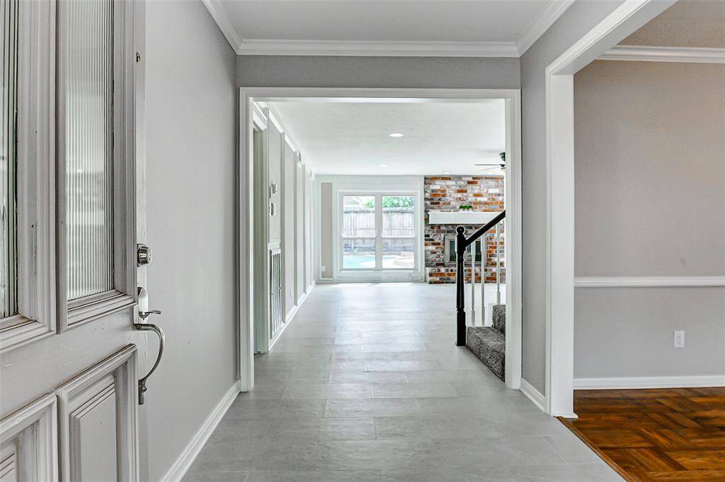 When you walk inside, you are greeted by a bright entryway with new tiled flooring leading to an open living area.