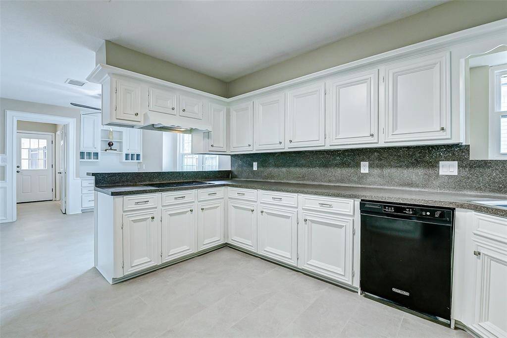 Bright and spacious kitchen featuring freshly painted white cabinets. The room has ample storage and natural light, creating a welcoming and functional space for cooking and entertaining.