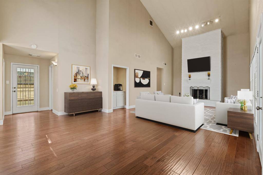 Virtually Staged: This spectacular living room features new hardwood floors, a gorgeous fireplace, a high ceiling, and incredible light fixtures.
