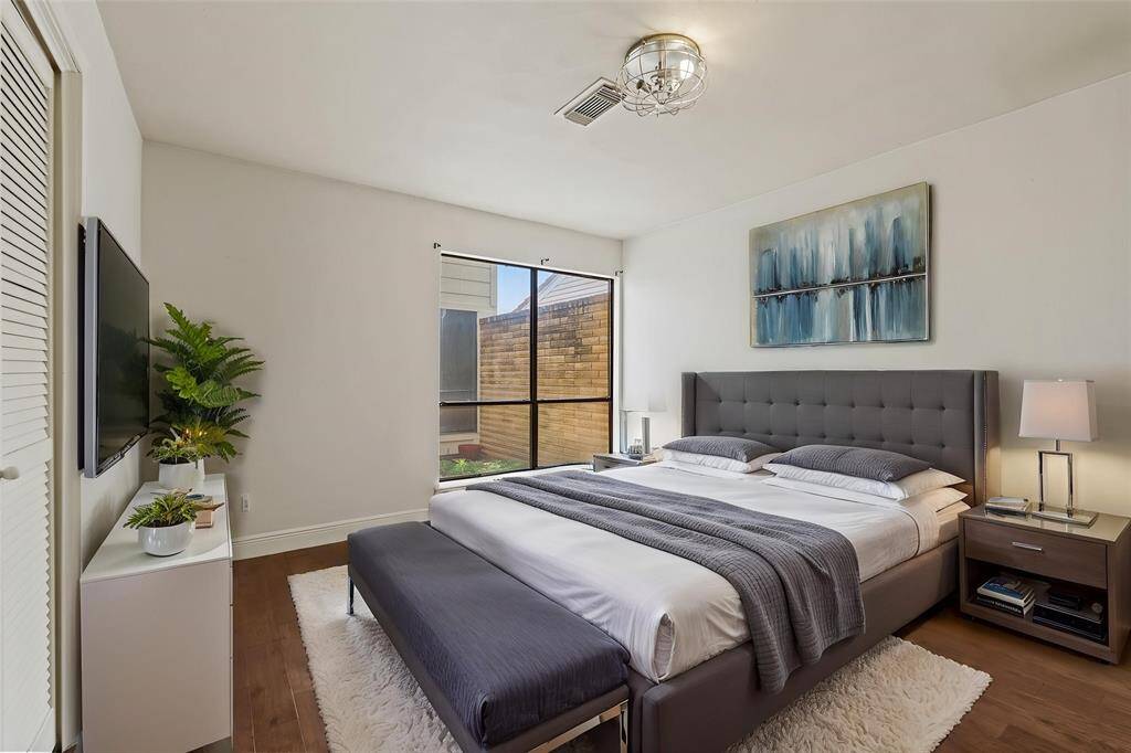 Virtually Staged: Secondary bedroom with hardwood floors, a built-in closet, and a large window.