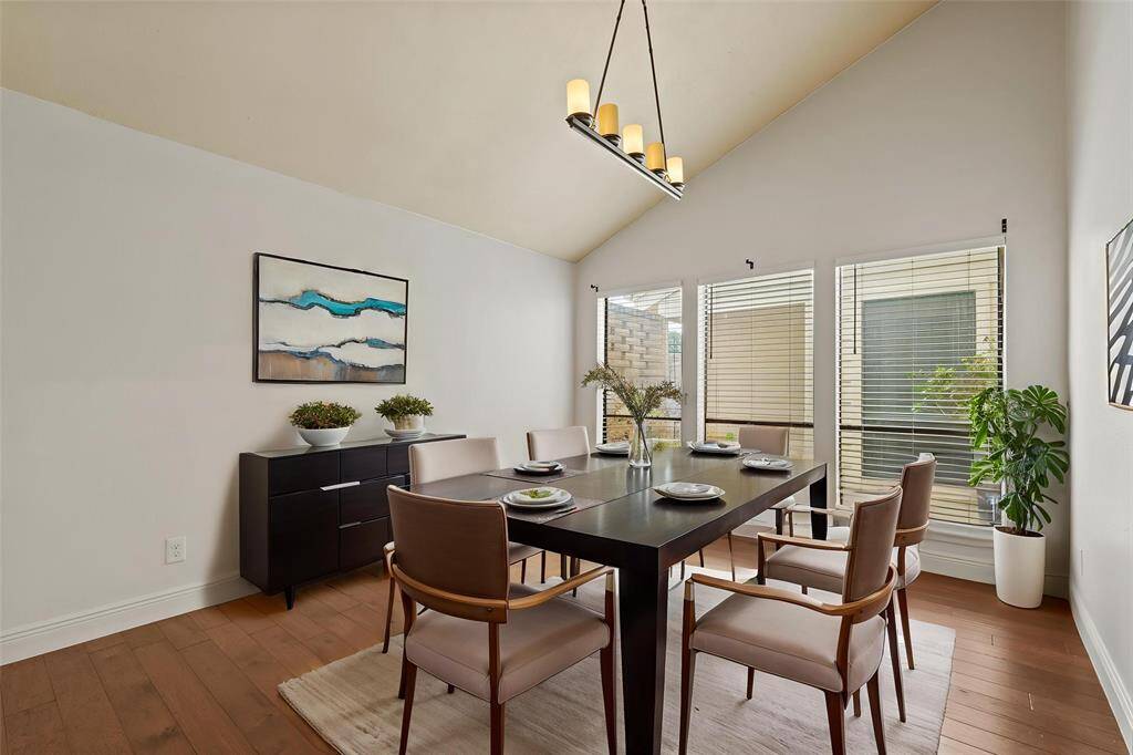 Virtually Staged: Spacious dining room with new hardwood floors, windows with privacy blinds, and pendant lighting.