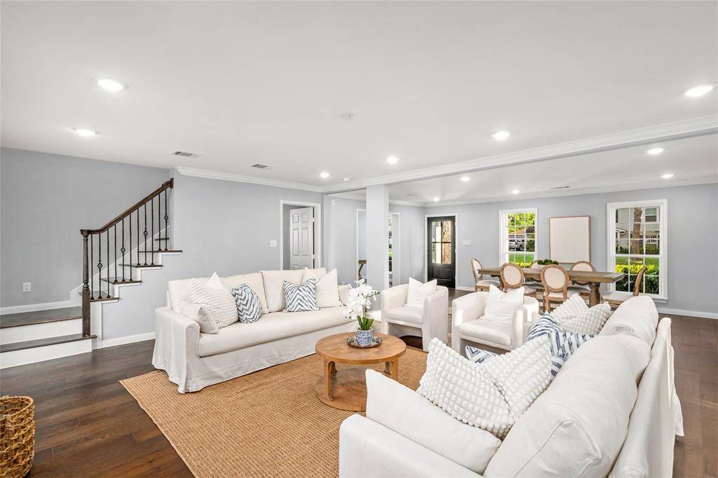 LIVING ROOM- View of the entrance to the primary suite. Staircase to four additional upstairs bedrooms is tucked away.