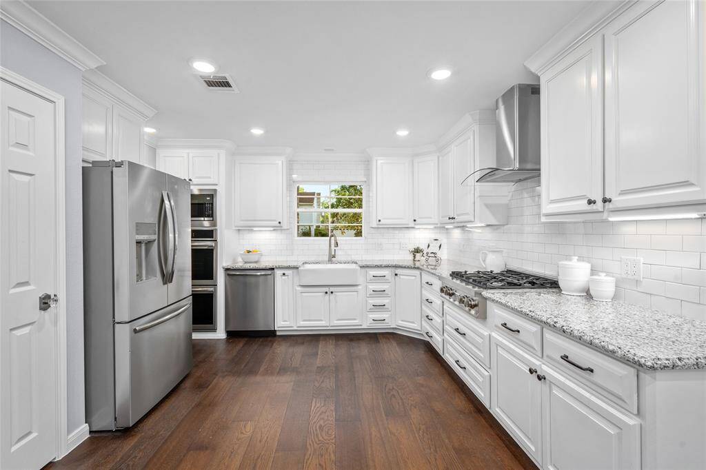 KITCHEN - Plenty of prep space and cabinets throughout the updated kitchen. Farmhouse sink, gas cooktop, double ovens.