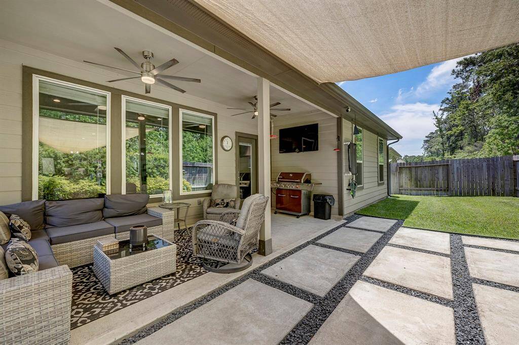 Upgraded hardscape to extend the covered back patio featuring ceiling fans for warm weather.