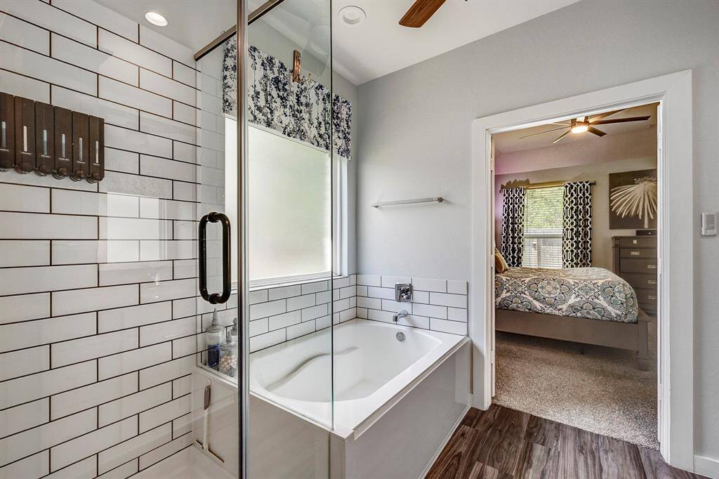 Double vanity, soaking tub and separate glass shower in primary bathroom oasis