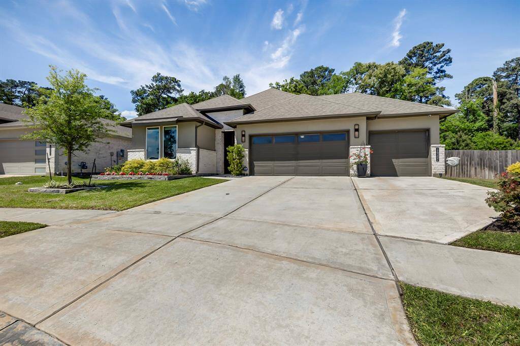 3 car garage with additional parking space and cameras on driveway and patio