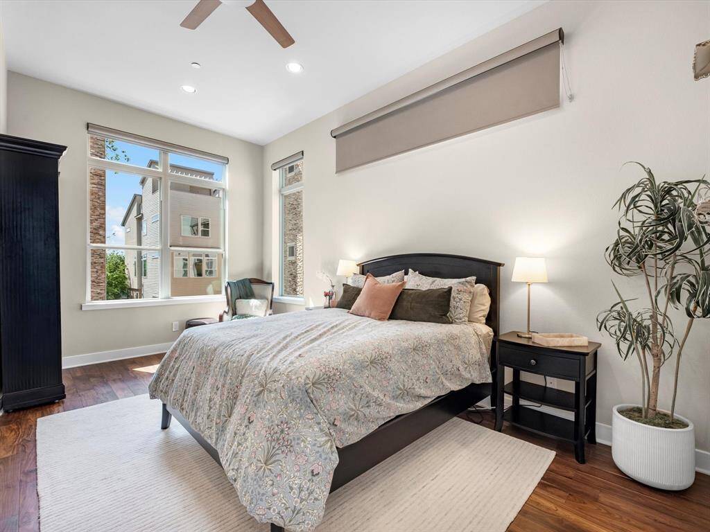 Bright and spacious dual primary bedroom with large windows that bring in abundant natural light. Hardwood floors and a clean, open layout create a warm and inviting retreat with plenty of room to relax.