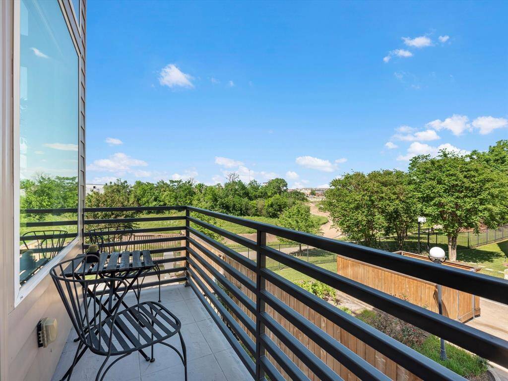 Private balcony with a sleek metal railing and cozy seating area, overlooking treetops and open sky. A peaceful spot to enjoy morning coffee or unwind at the end of the day.