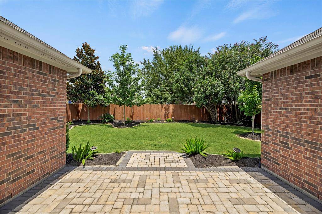 Impeccable backyard with paver stone patio and tasteful landscaping, perfect for relaxation and entertainment !