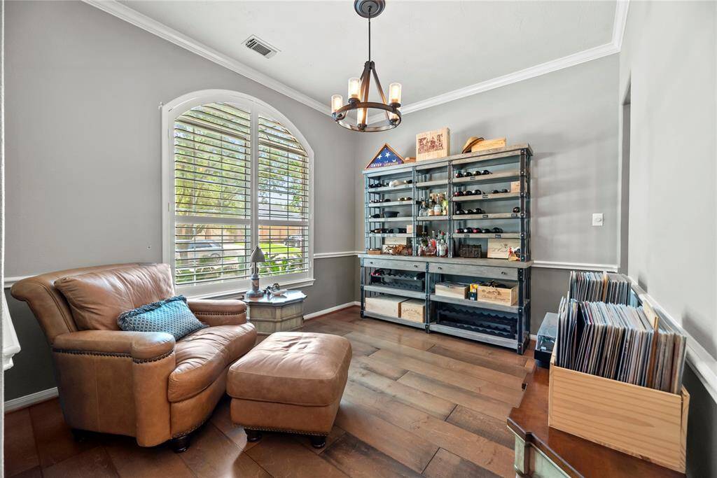 This versatile room can serve as dining area or a more formal seating space, it features crown molding and plantation shutters , connecting seamlessly to the kitchen.