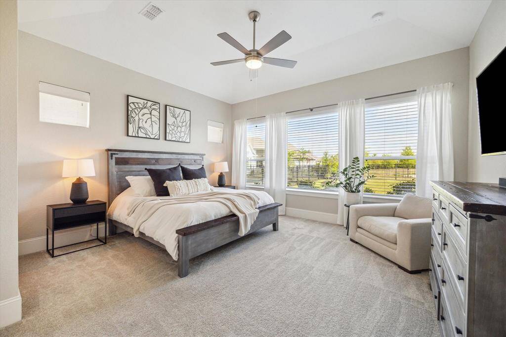 The primary suite has great views of the backyard and lake.