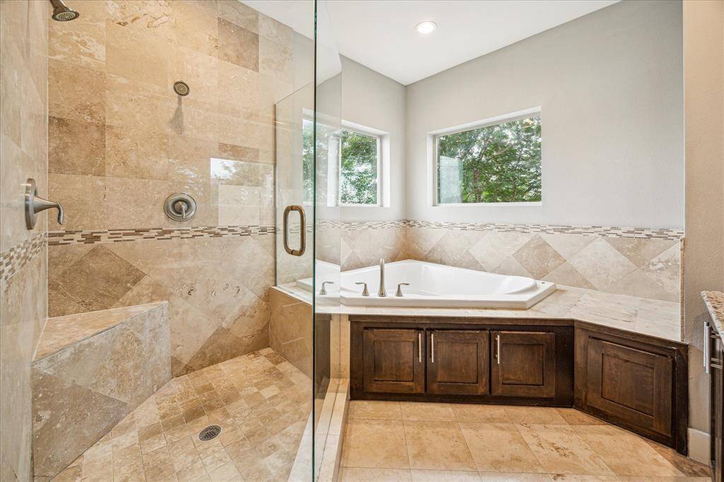 Dream bathroom with seamless shower enclosure, tub and exceptional natural lighting.