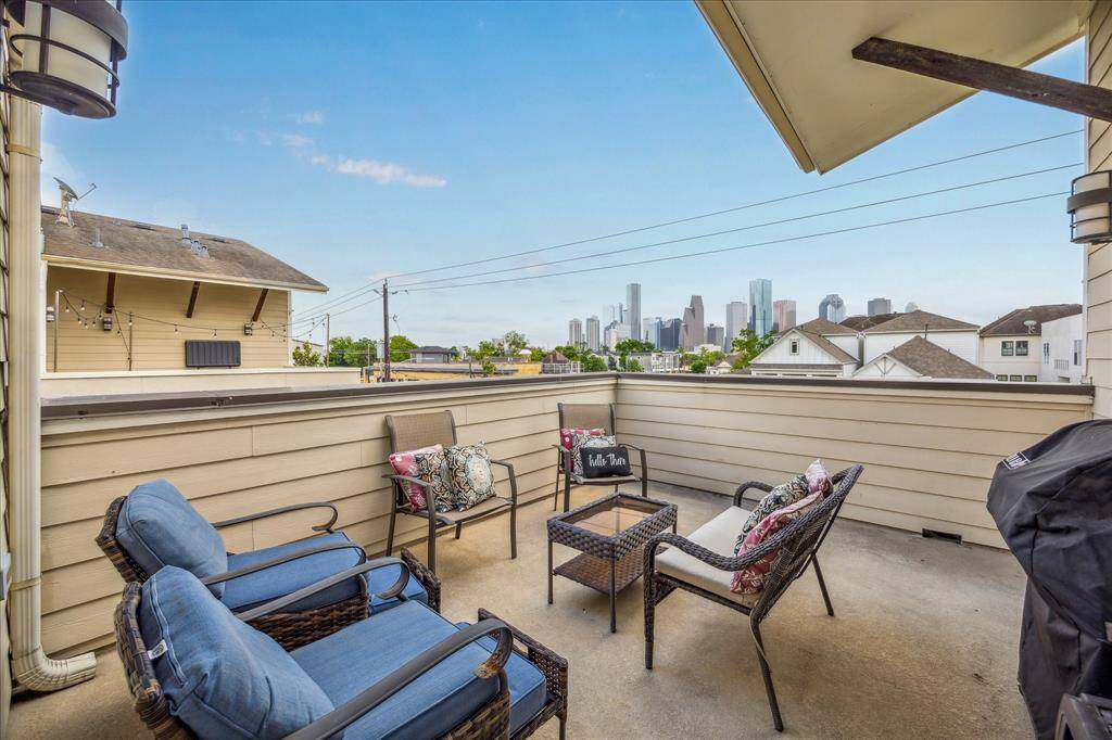 View of this cozy rooftop patio featuring comfortable seating and a stunning view of the city skyline, perfect for relaxation and entertaining.