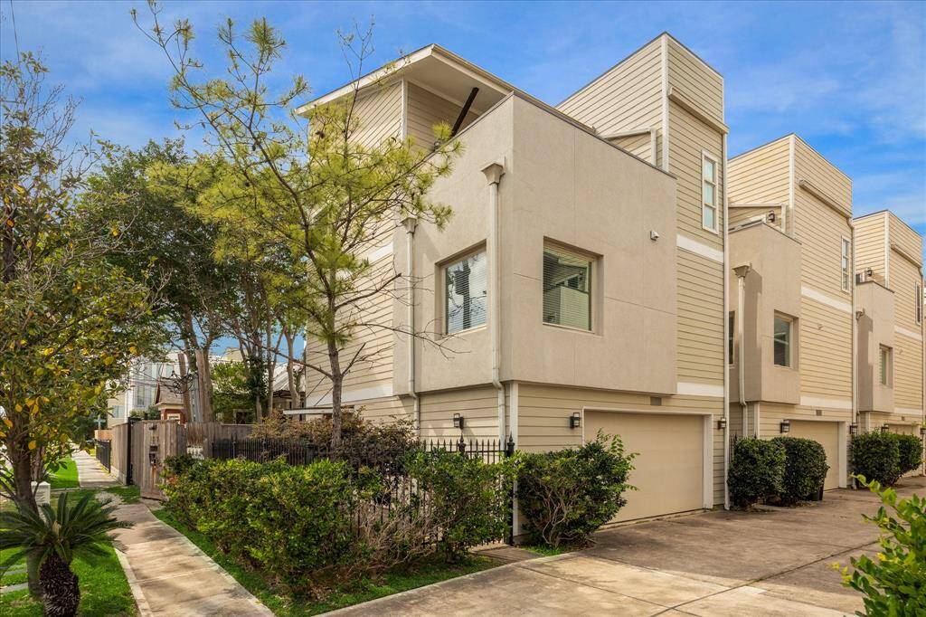 Corner single family home with a contemporary design, featuring a clean exterior and attached garage. Located in a well-maintained neighborhood with lush greenery and a paved walkway, offering a welcoming and practical living space.