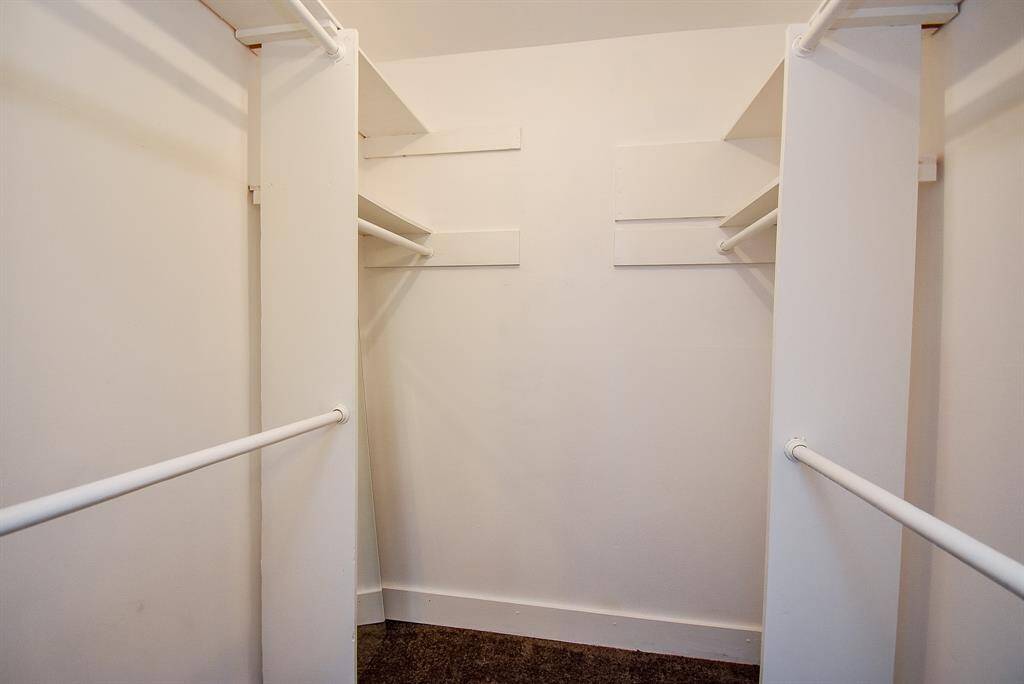 A supersized walk-in primary closet with plenty of hanging rods and shelves, providing abundant storage and organization space.