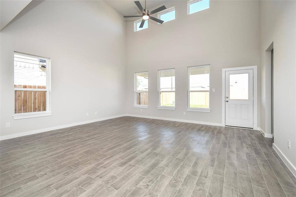 Gather the family and guests together in your lovely living room! Featuring soaring highceilings, recessed lighting, ceiling fan, custom paint, gorgeous floors, and large windows thatprovide plenty of natural lighting throughout the day. Sample photo of completed home with similar floor plan. Actual colors and selections may vary.