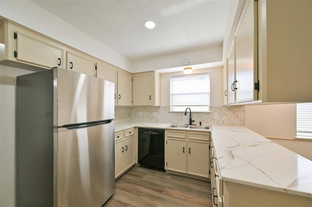 THE KITCHEN HAS BEEN TASTEFULLY UPDATED WITH GRANITE COUNTERS AND NEUTRAL HERRINGBONE BACK-SPLASH. BONUS THE REFRIGERATOR STAYS.